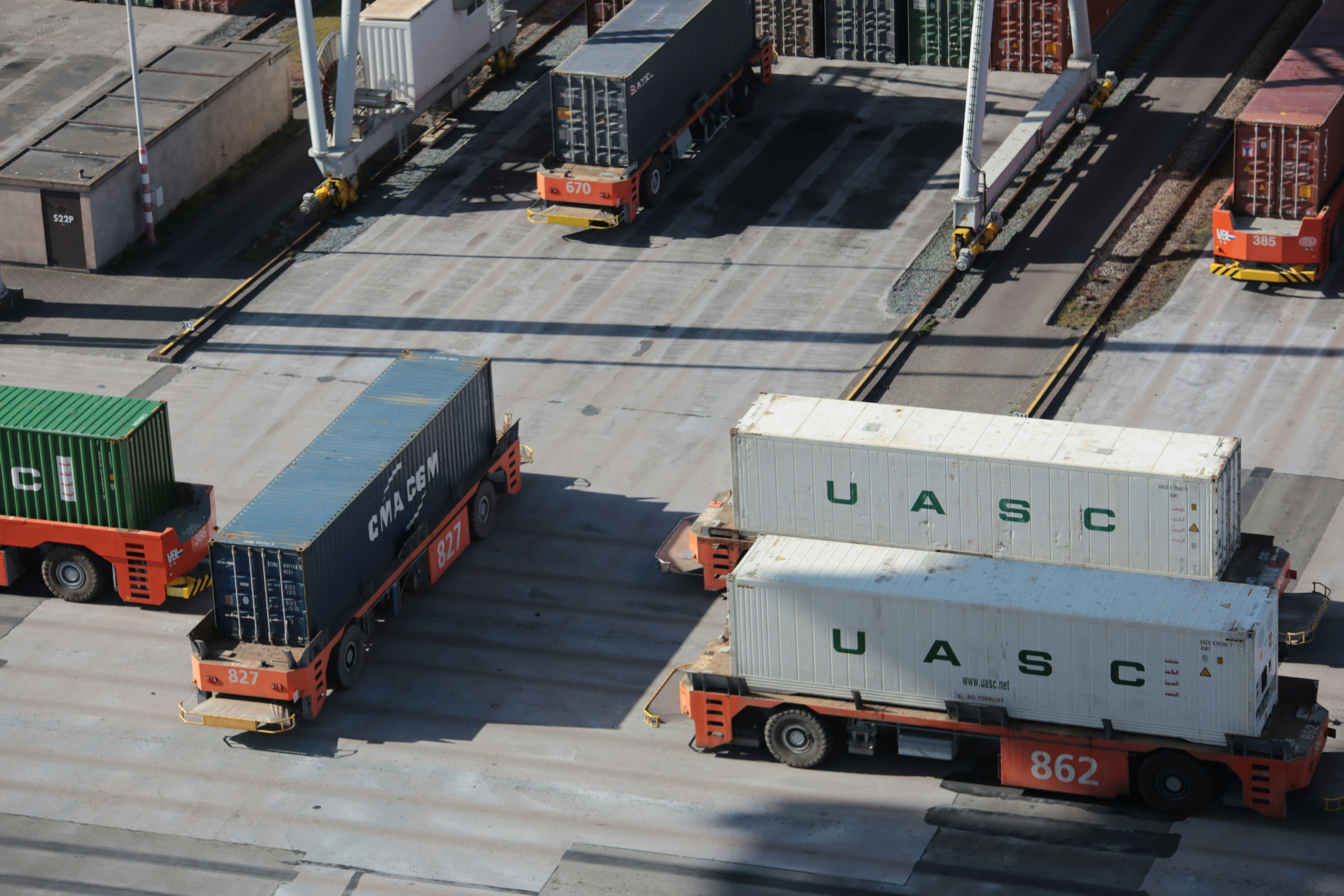 Straddle carriers moving shipping containers at a commercial port