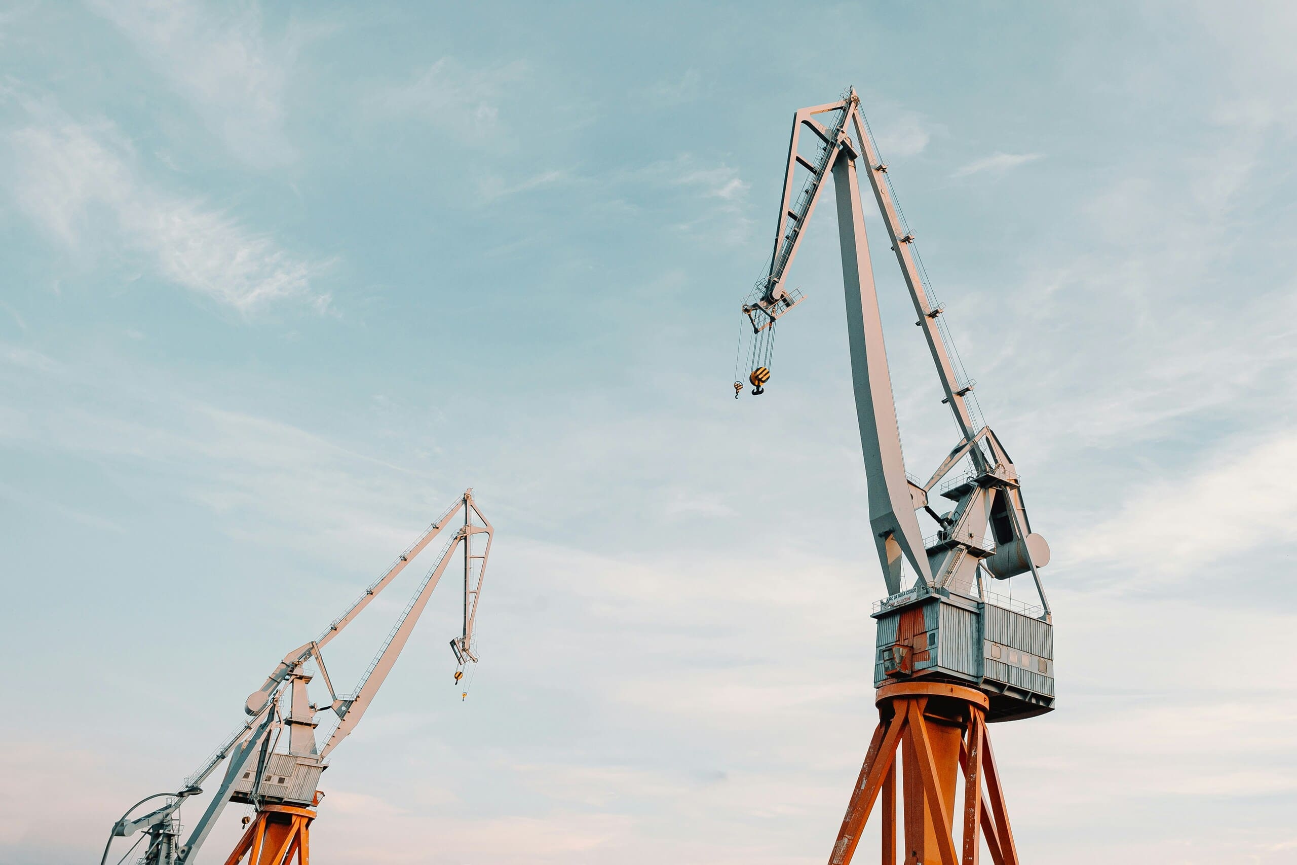 Industrial port cargo cranes against a clear blue sky