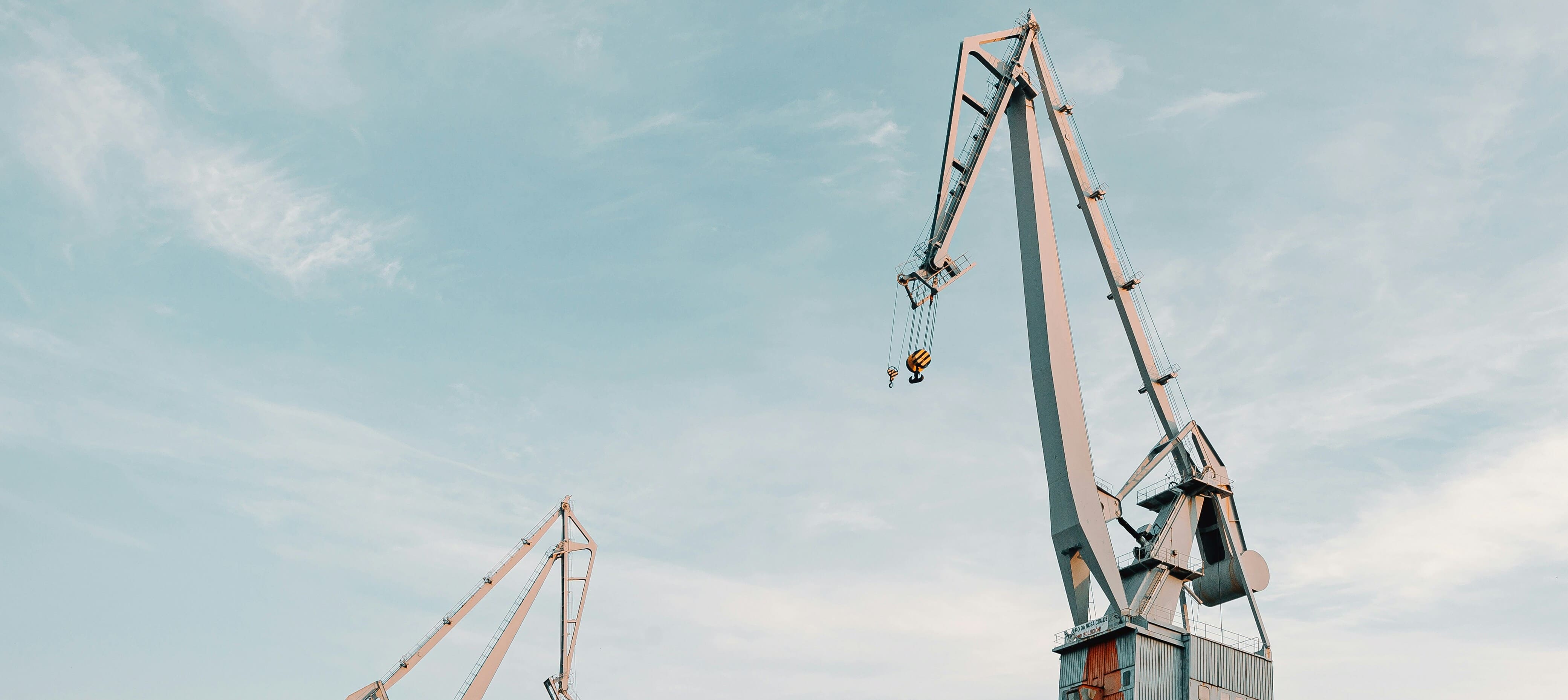 Industrial port cargo cranes against a clear blue sky