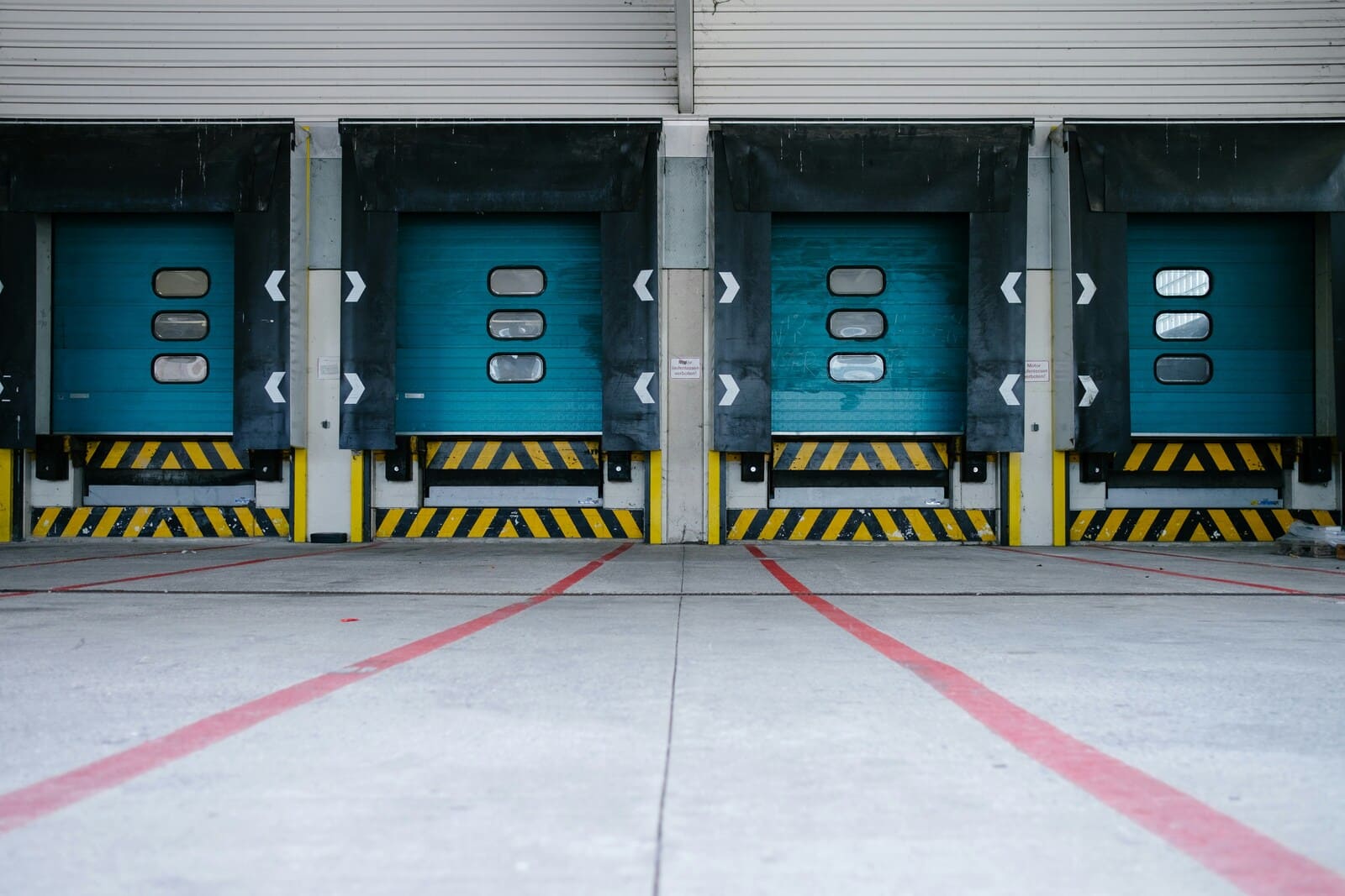 Row of warehouse loading docks with industrial doors and safety markings